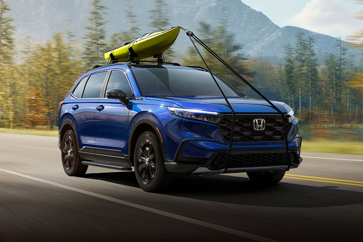 2025 Honda CR-V Sport Touring Hybrid in Canyon River Blue Metallic front driving with a kayak (Compact Crossover SUV).