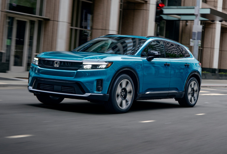 Blue Honda Prologue driving through a city