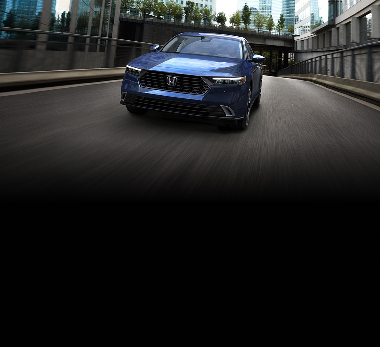 A Honda Accord in Canyon River Blue Metallic driving on a city road.
